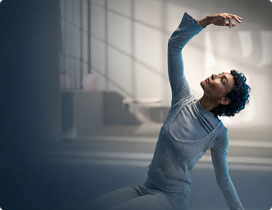 Person wearing hearing aids stretching in a bright indoor space