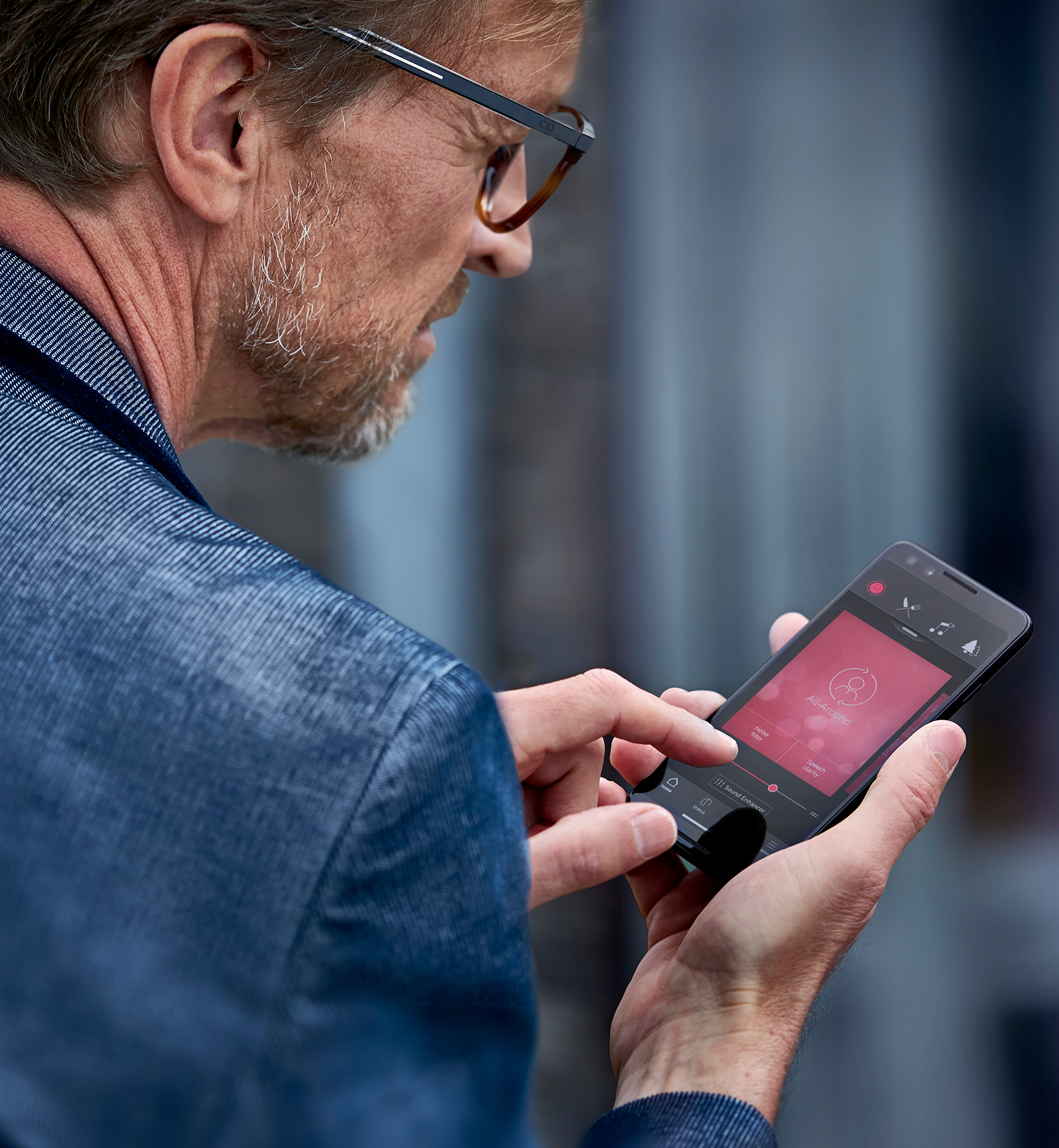 Mulher com auxílio auditivo ReSound LiNX3D e transmissão de som para eles através do seu telefone Android.