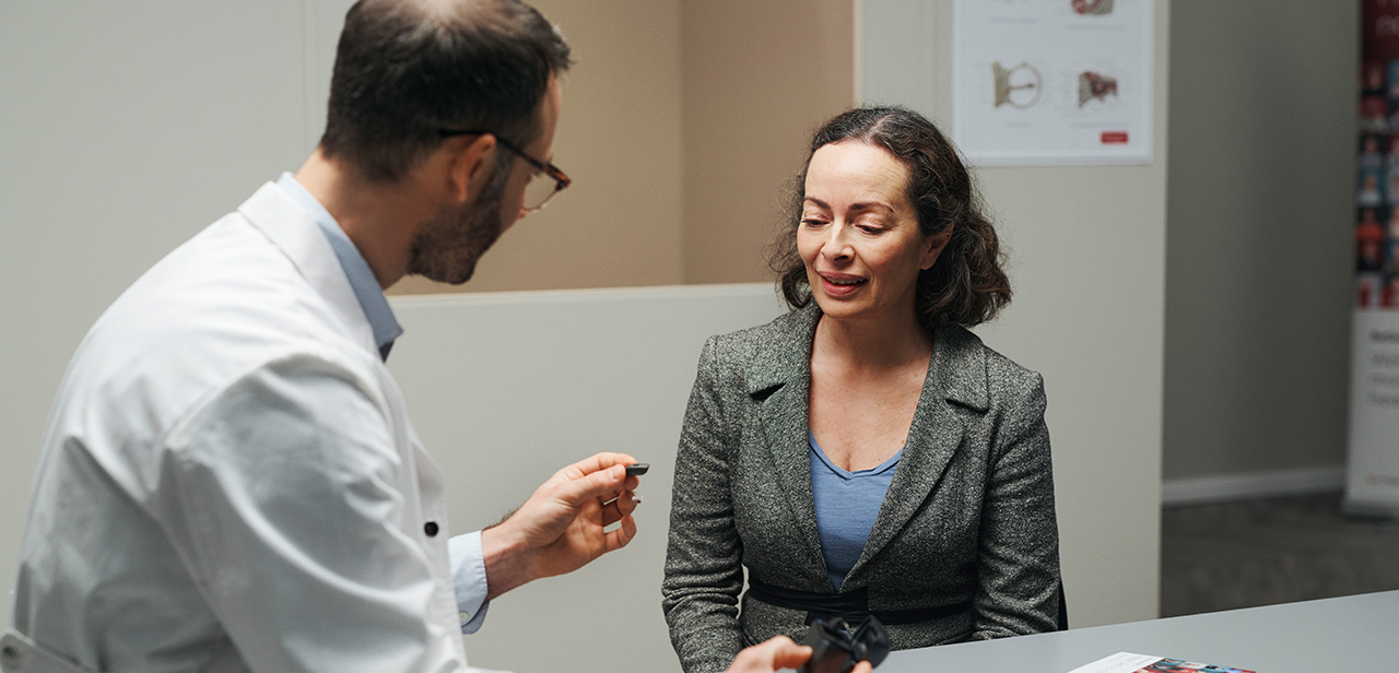 ReSound audioprothésiste interagissant avec un patient lors d'un rendez-vous.