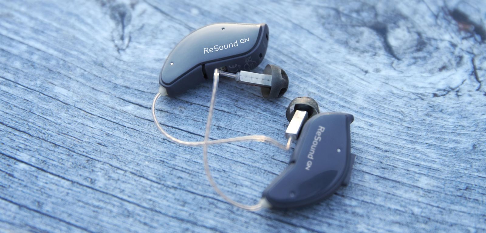Zwei kleine ReSound-Hörsysteme auf einem Tisch.