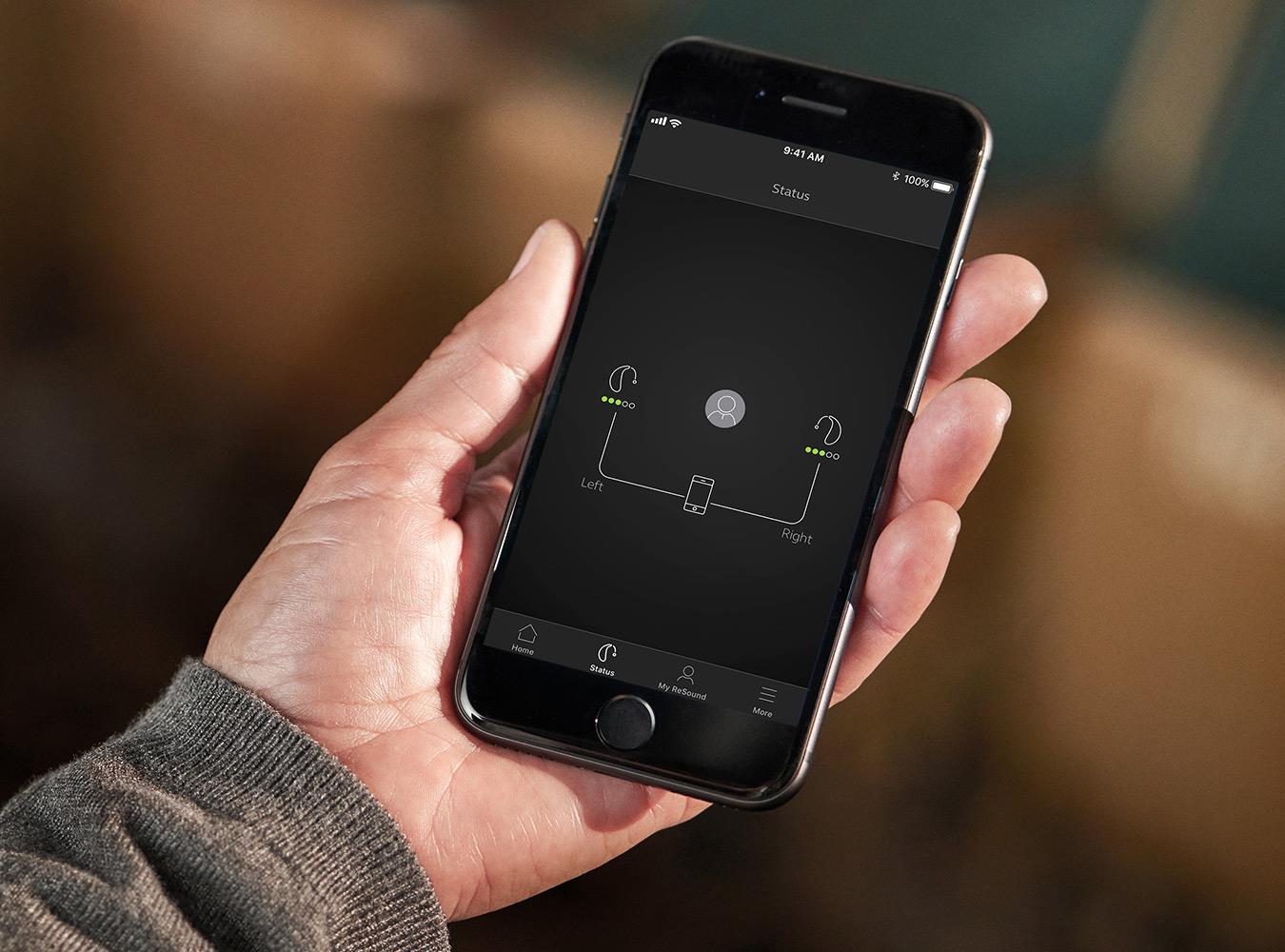 Uomo che controlla l'utilizzo della batteria di ReSound LiNX Quattro tramite il suo telefono.