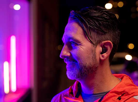 Homme à l’extérieur avec les aides auditives personnalisées ReSound ONE dans l’oreille