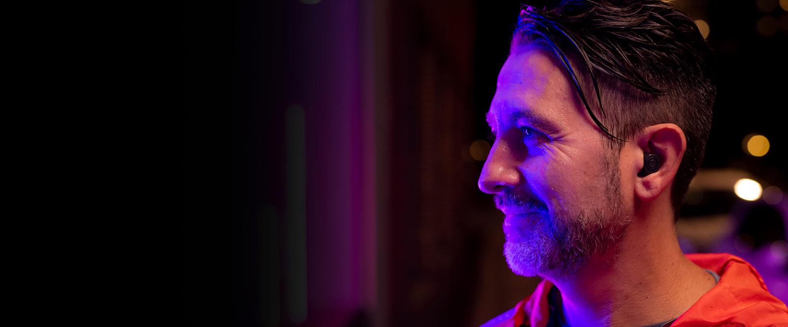 Homme à l’extérieur avec les aides auditives personnalisées ReSound ONE dans l’oreille