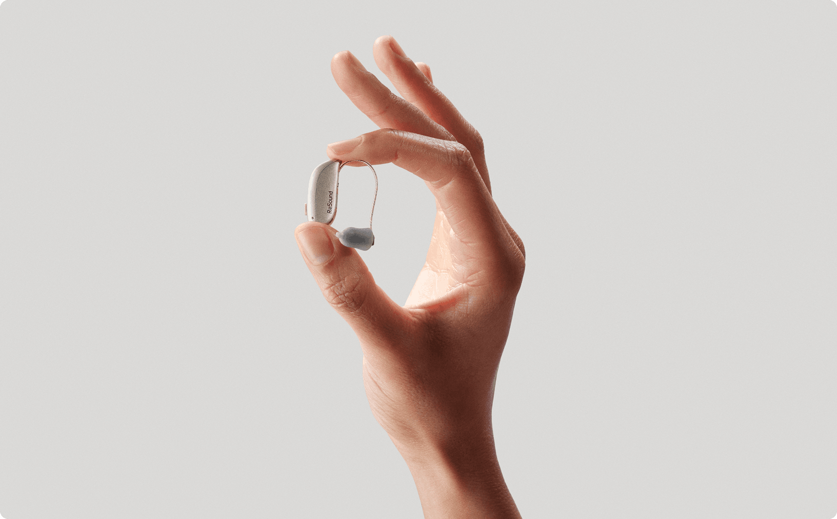 Hand holding ReSound Sensia hearing aid