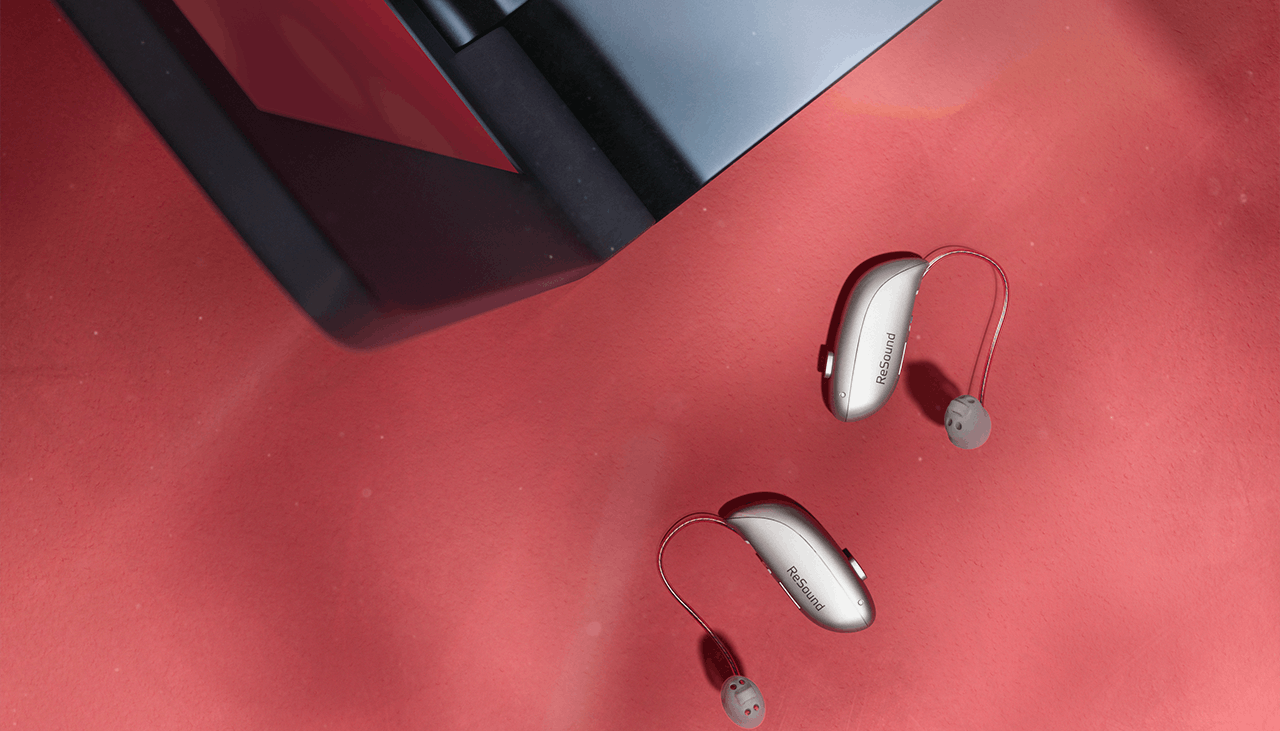 ReSound Sensia hearing aids next to a laptop