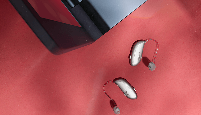 ReSound Sensia hearing aids next to a laptop
