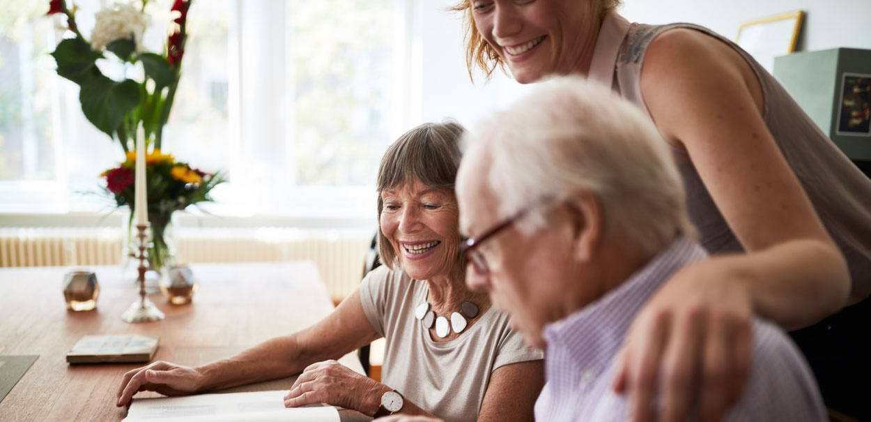 Avó usando aparelhos auditivos e conversando com seus netos.